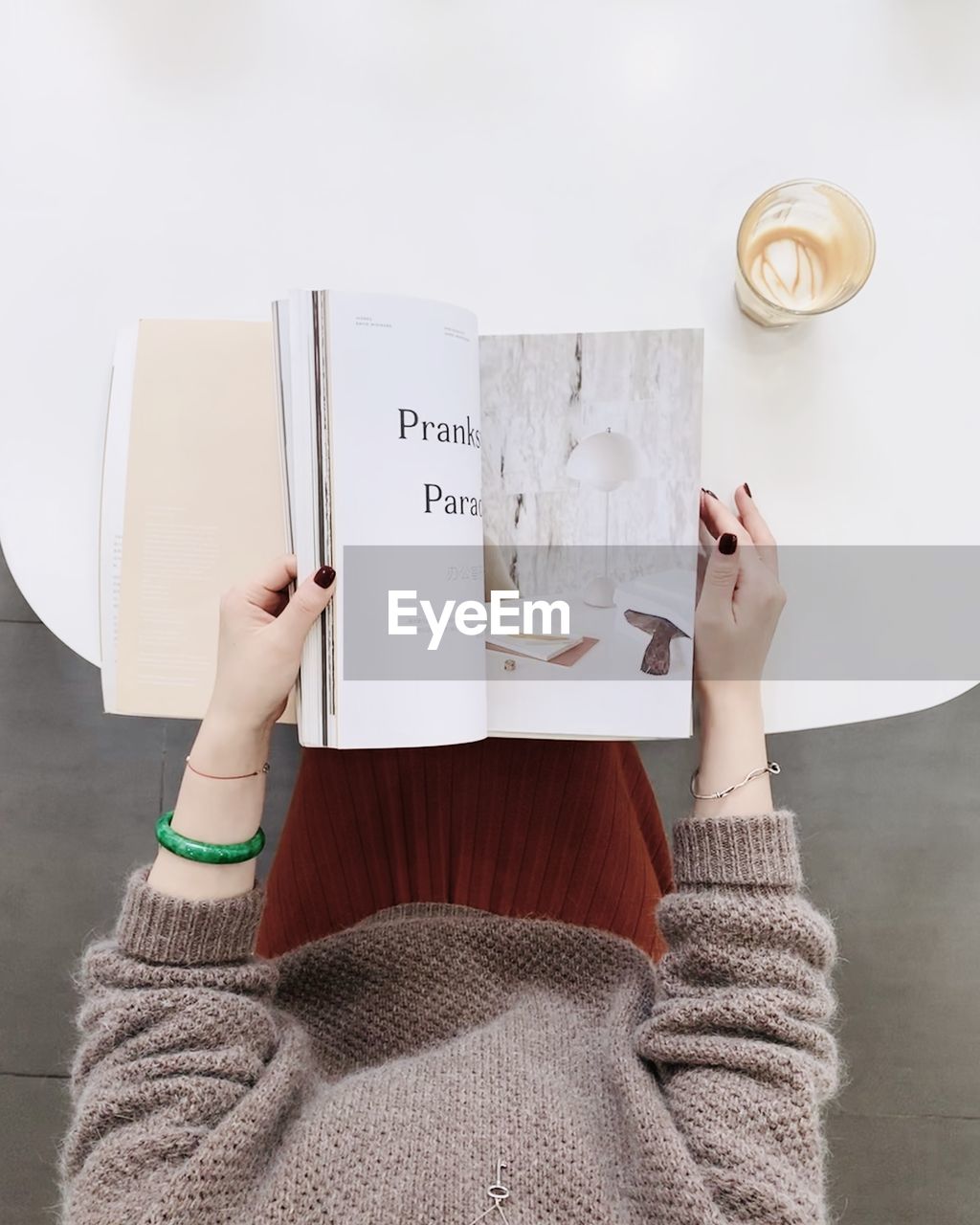 LOW SECTION OF WOMAN READING BOOK ON PAPER