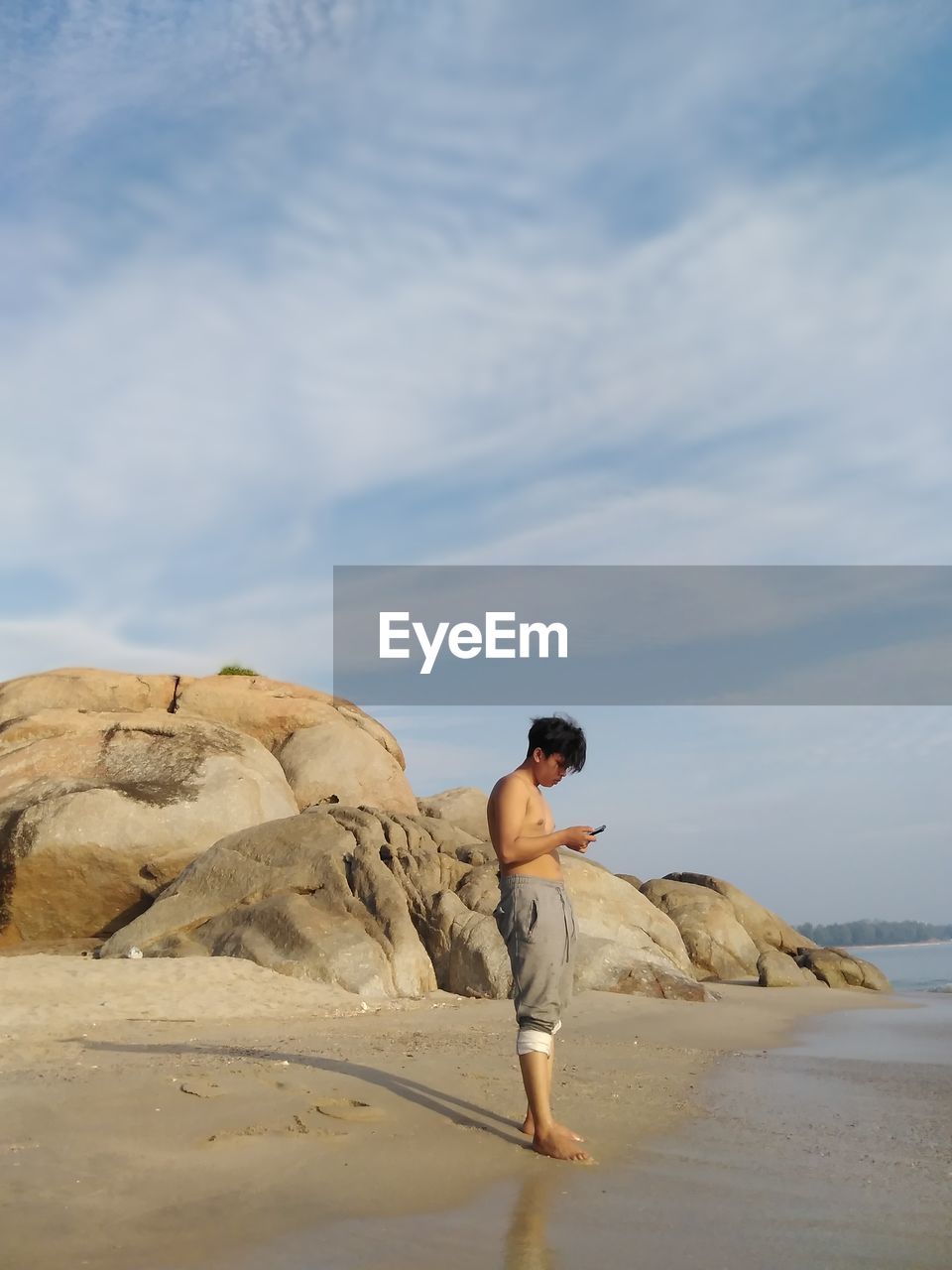 Man standing at beach against sky