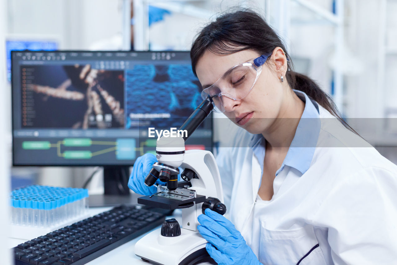 young woman using mobile phone while working at laboratory