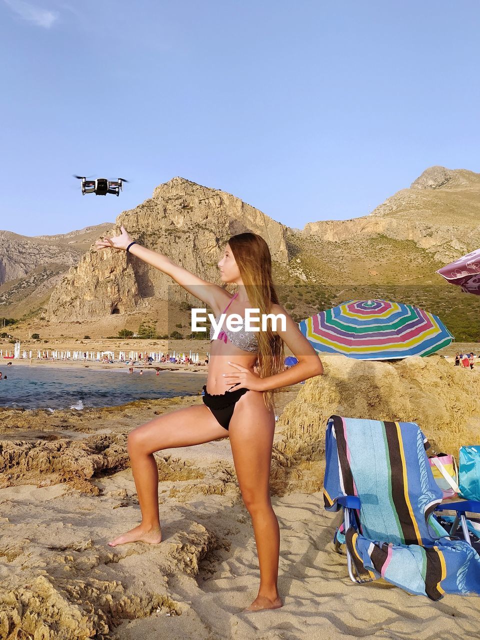 Little girl at the seaside plays with a drone