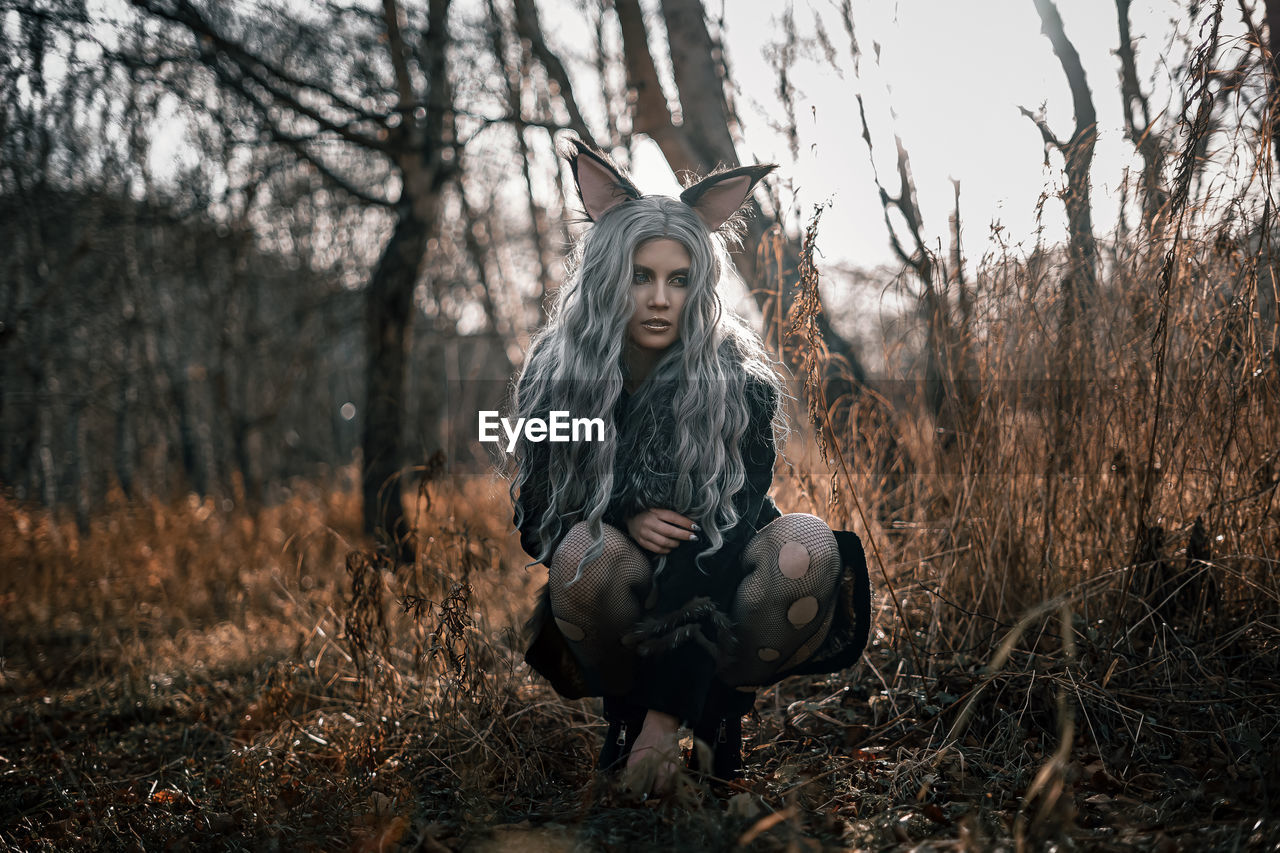 Young woman standing against tree during autumn