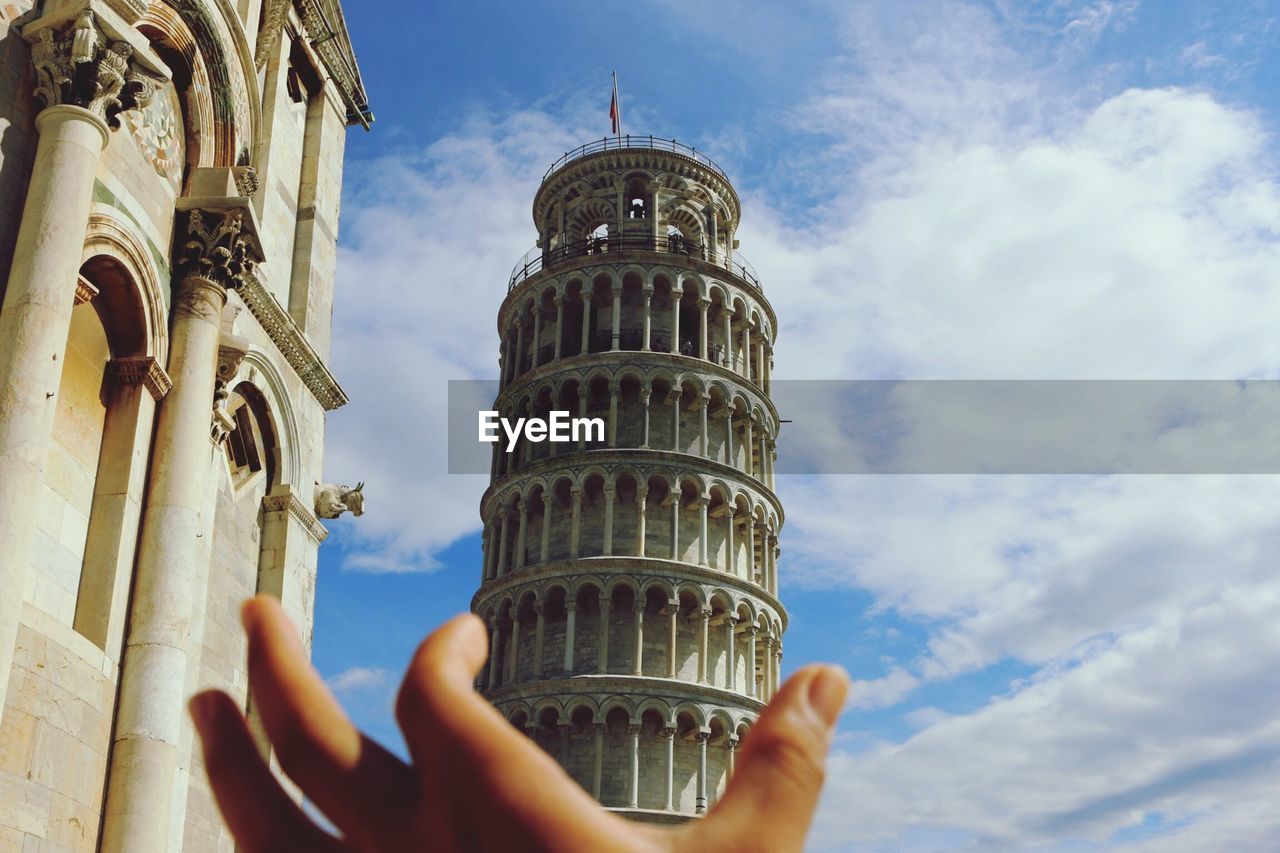Person holding the leaning tower of pisa