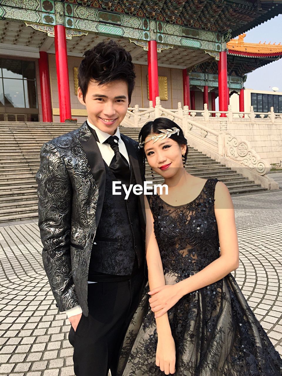 Portrait of smiling young couple standing against temple