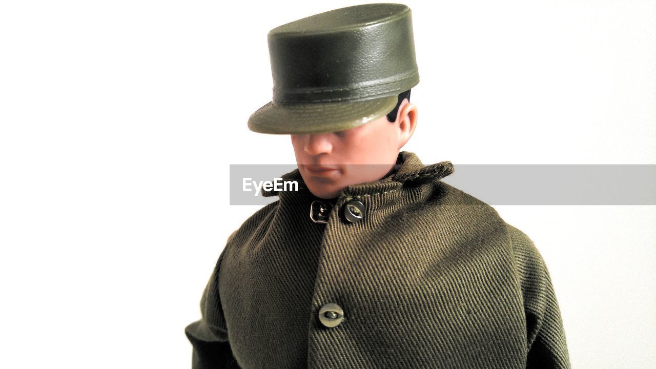 MIDSECTION OF MAN WEARING HAT AGAINST WHITE BACKGROUND