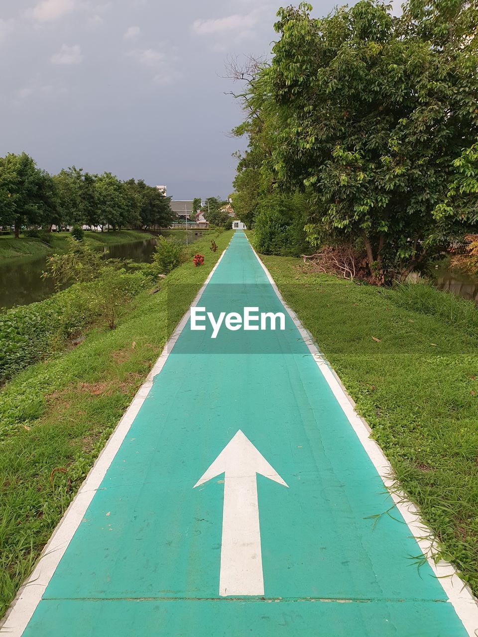 Road sign on field against sky