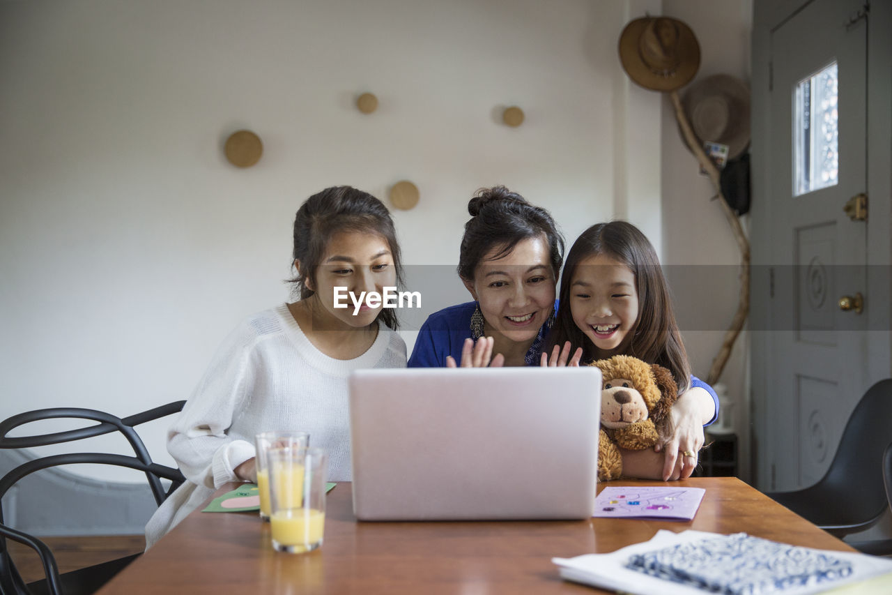 Happy family doing video call with laptop at home