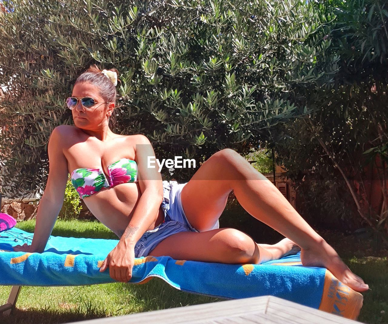 Young woman sitting on bench in swimming pool