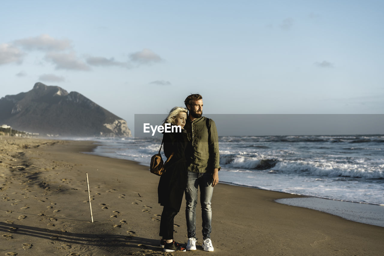 Portrait of man standing on beach against sky