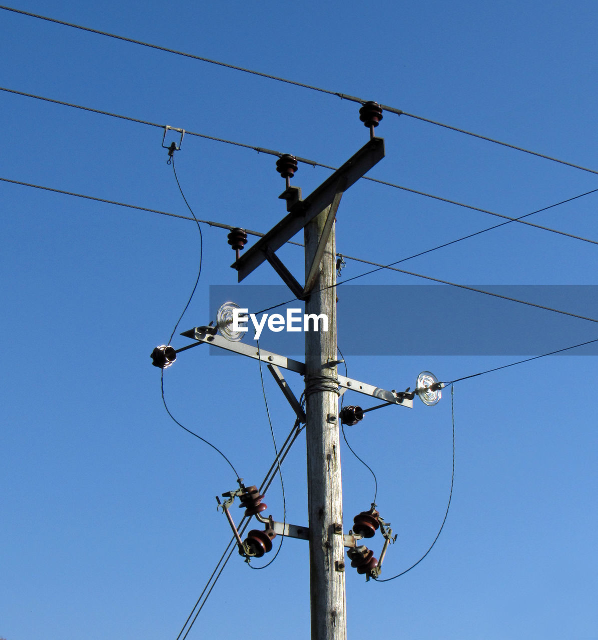 LOW ANGLE VIEW OF POWER LINES AGAINST CLEAR BLUE SKY