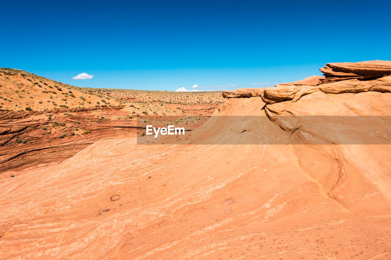 Scenic view of desert against blue sky