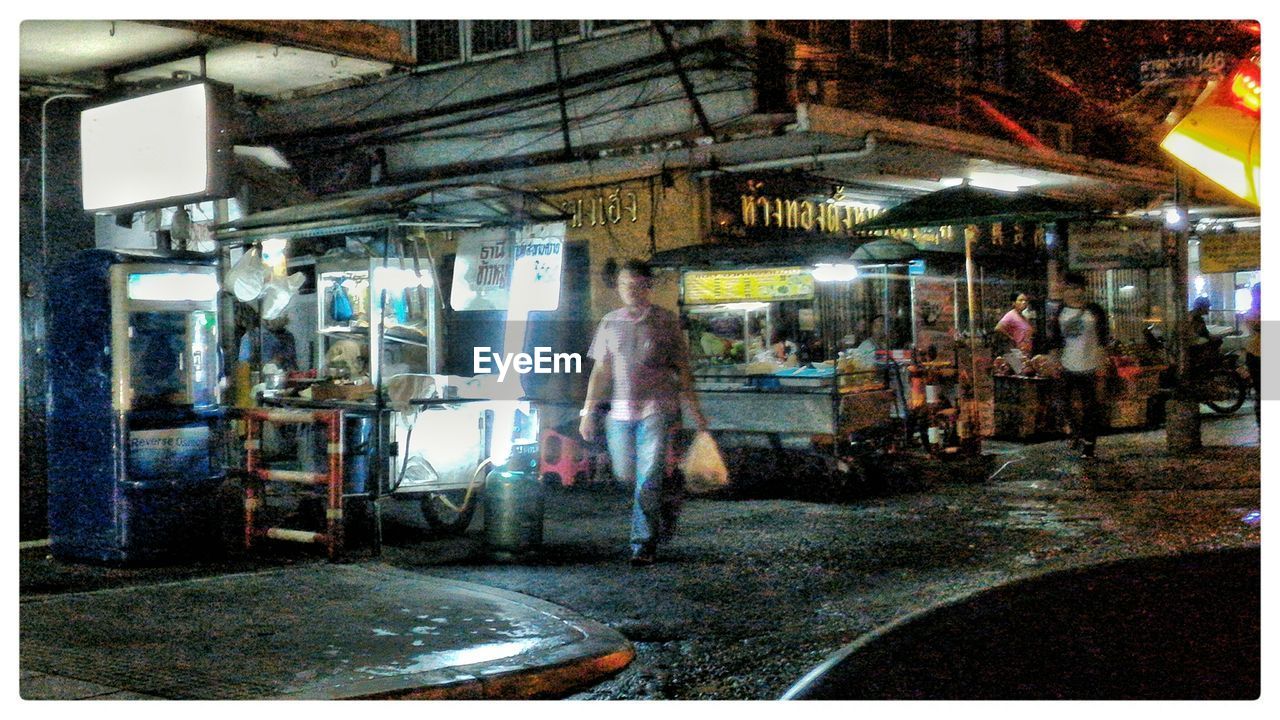 People at illuminated street market at night