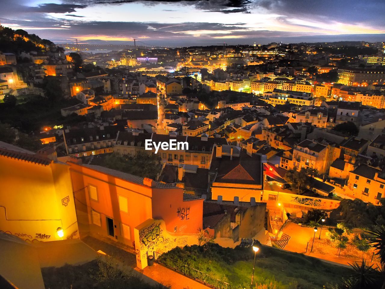 HIGH ANGLE VIEW OF ILLUMINATED CITY AGAINST SKY