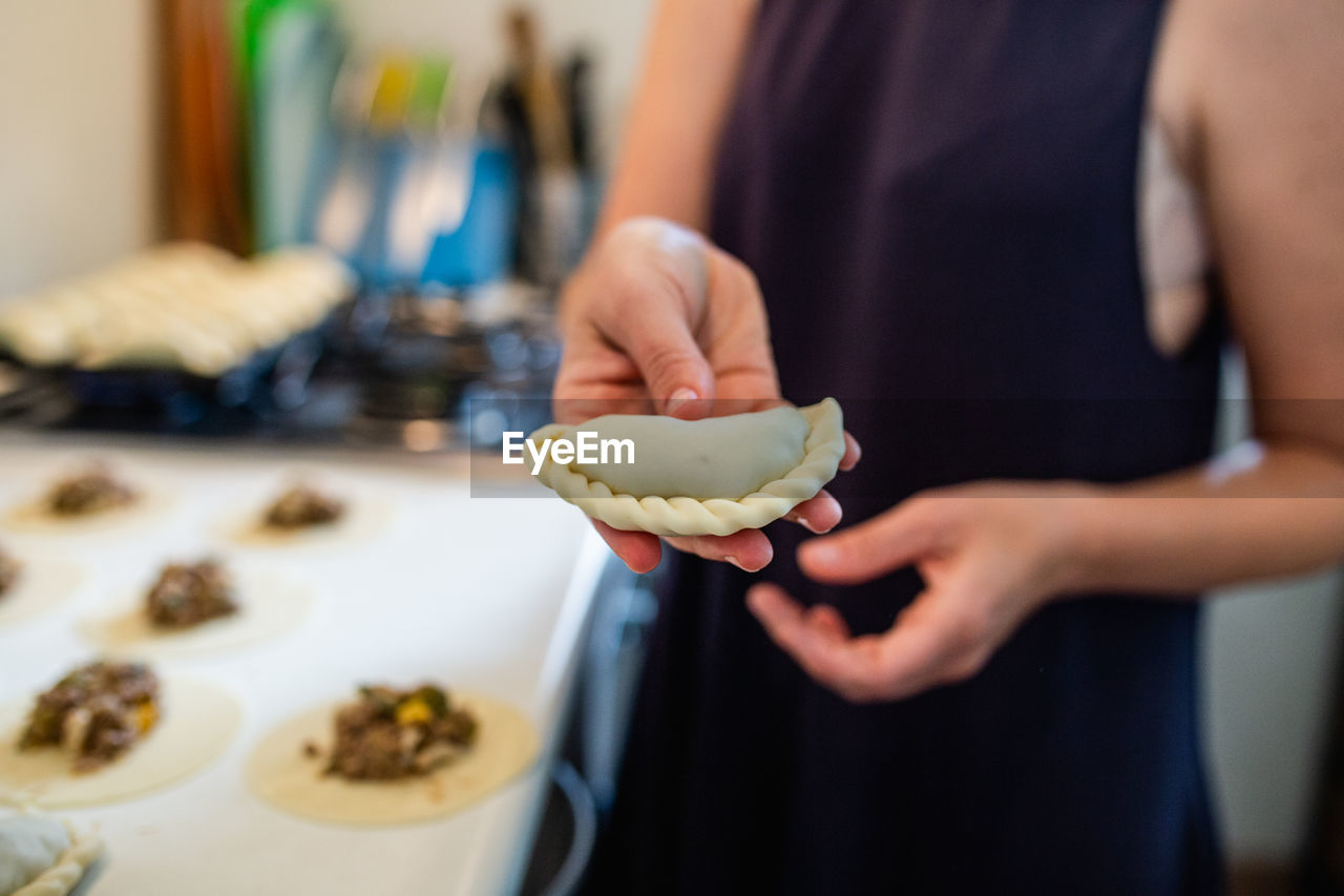 MIDSECTION OF WOMAN PREPARING FOOD