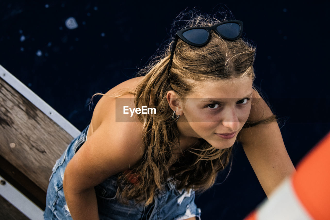 Portrait of young woman wearing sunglasses in boat