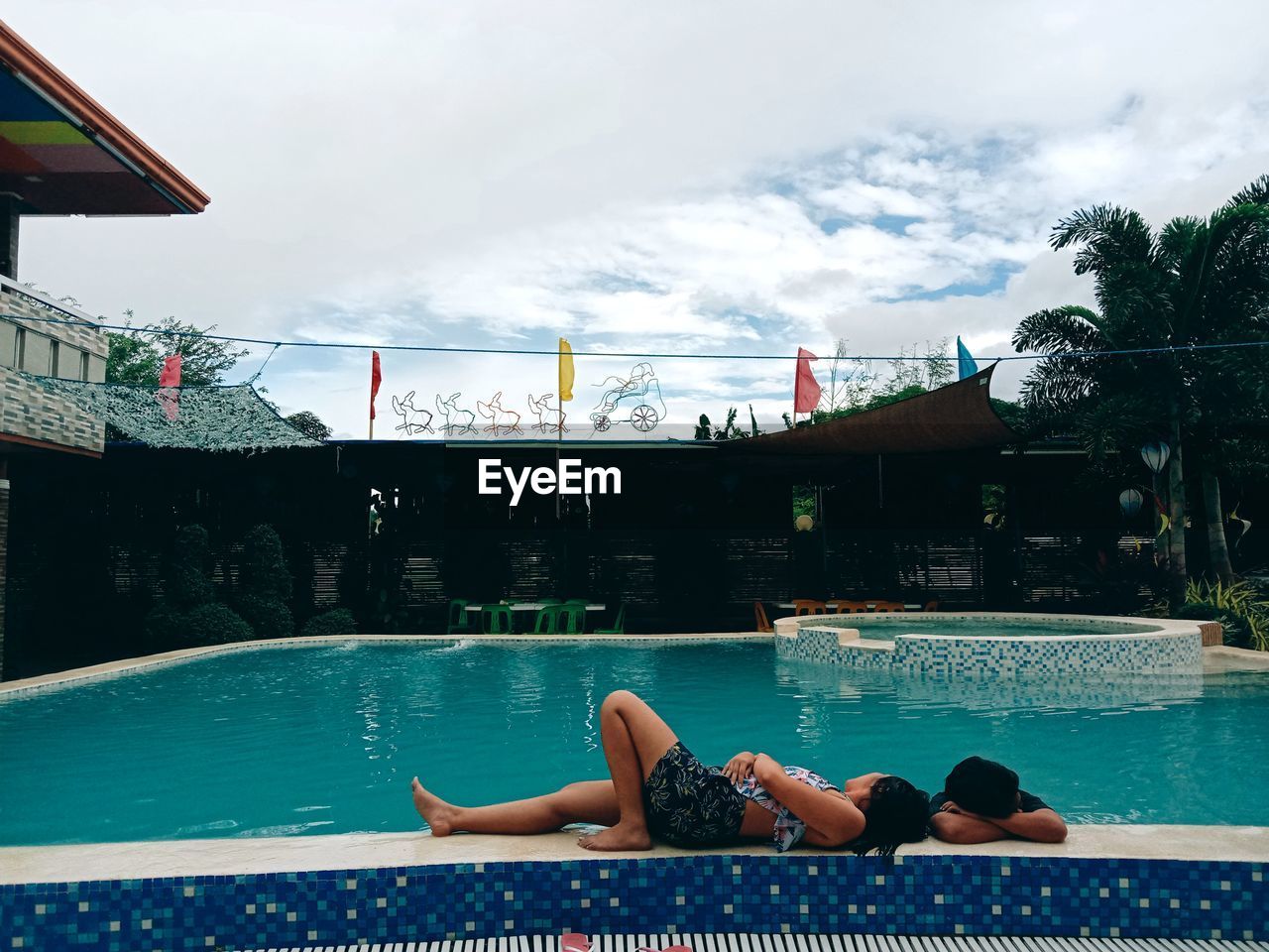 WOMAN RELAXING IN SWIMMING POOL