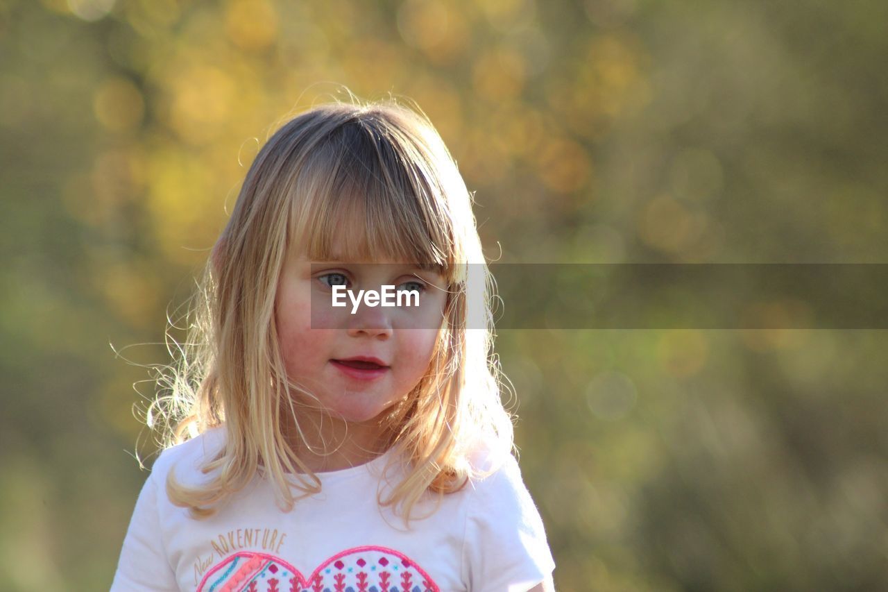 Close-up of girl looking away while standing outdoors