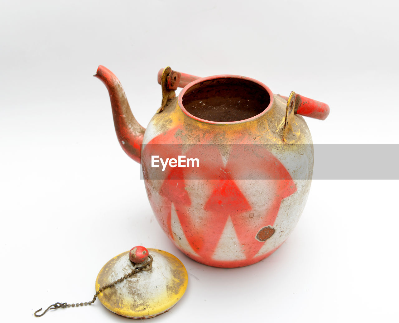 Close-up of weathered teapot over white background