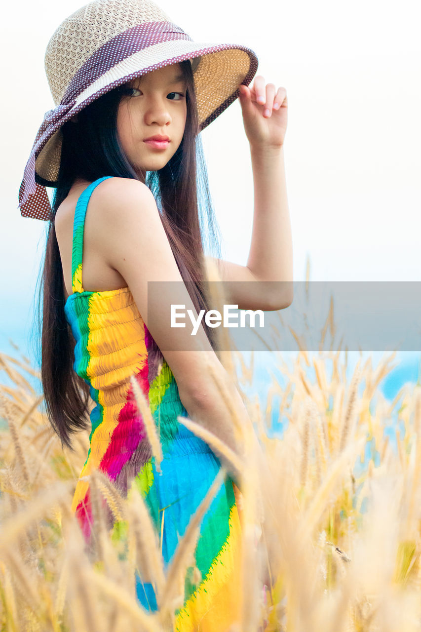 Girl wearing hat standing on field