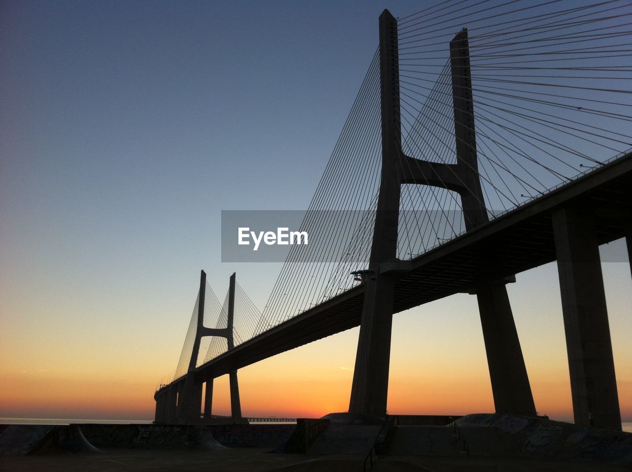 Low angle view of suspension bridge at sunset