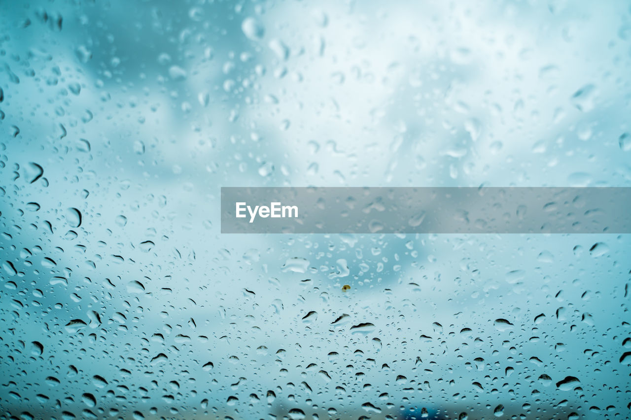 FULL FRAME SHOT OF WET GLASS WINDOW DURING RAINY SEASON