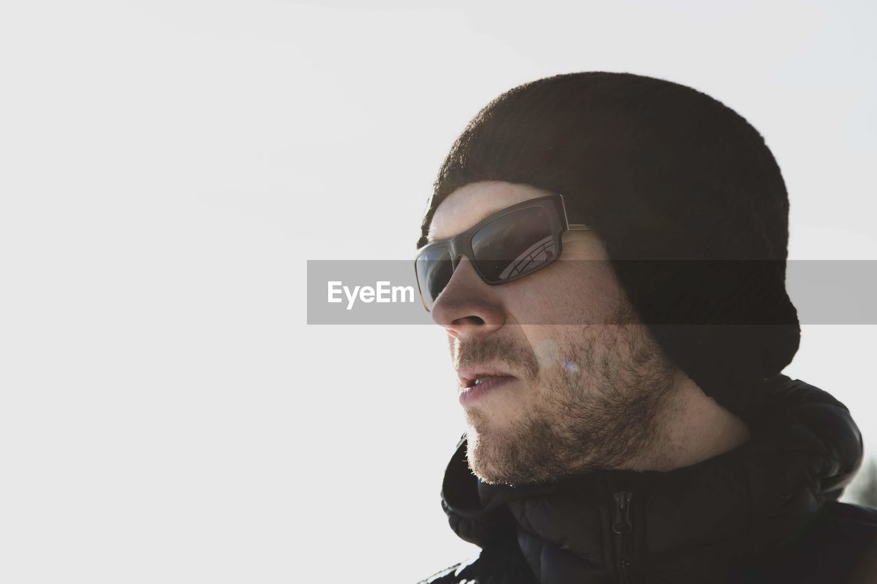 Close-up of thoughtful man wearing sunglasses and knit hat