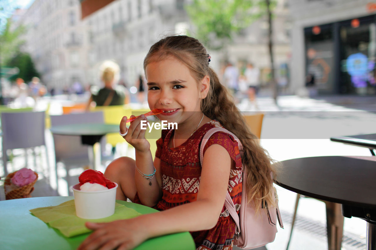 Portrait of smiling woman sitting on table at cafe