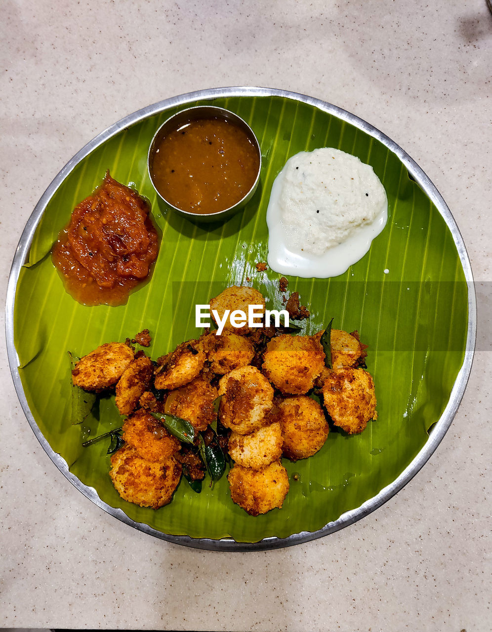 food and drink, food, dish, freshness, healthy eating, produce, indian food, no people, banana leaf, indian cuisine, wellbeing, vegetable, asian food, cuisine, high angle view, plate, fried, green, indoors, sauce, savory food, still life, meat, bowl, vegetarian food, meal, directly above