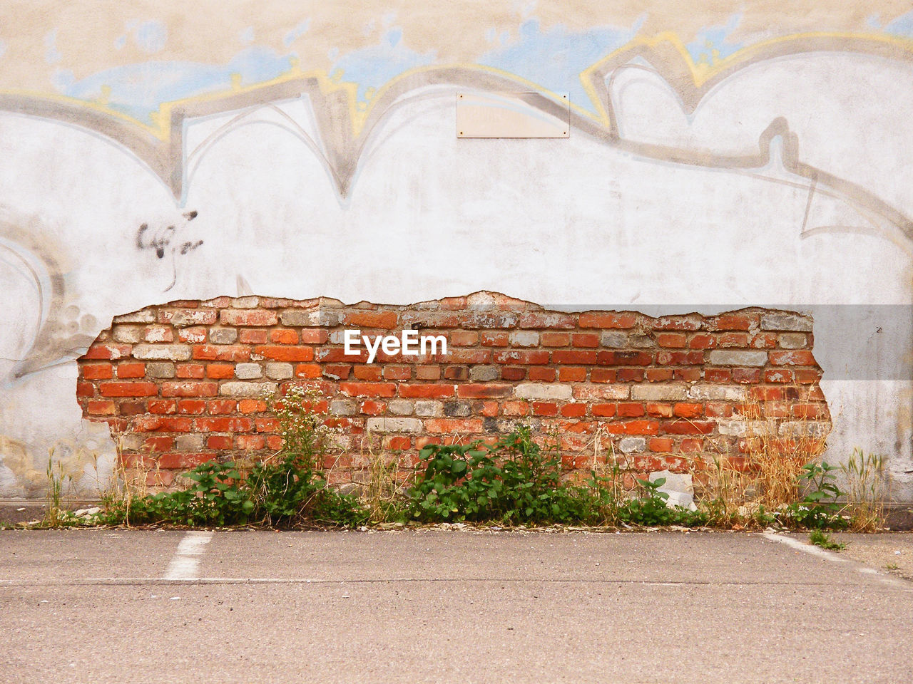 BRICK WALL WITH GRAFFITI ON STONE WALLS