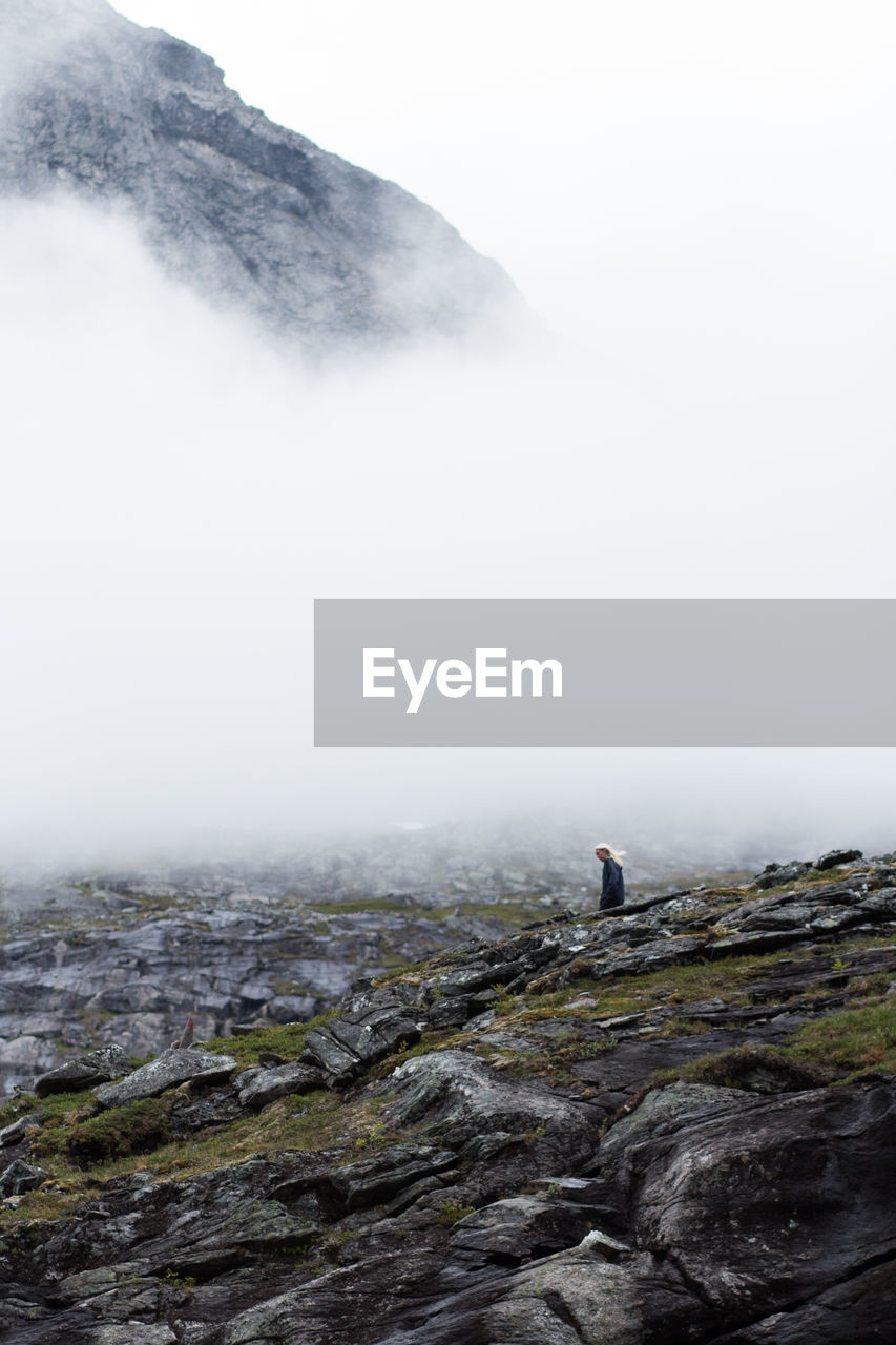 Scenic view of person on mountain against sky