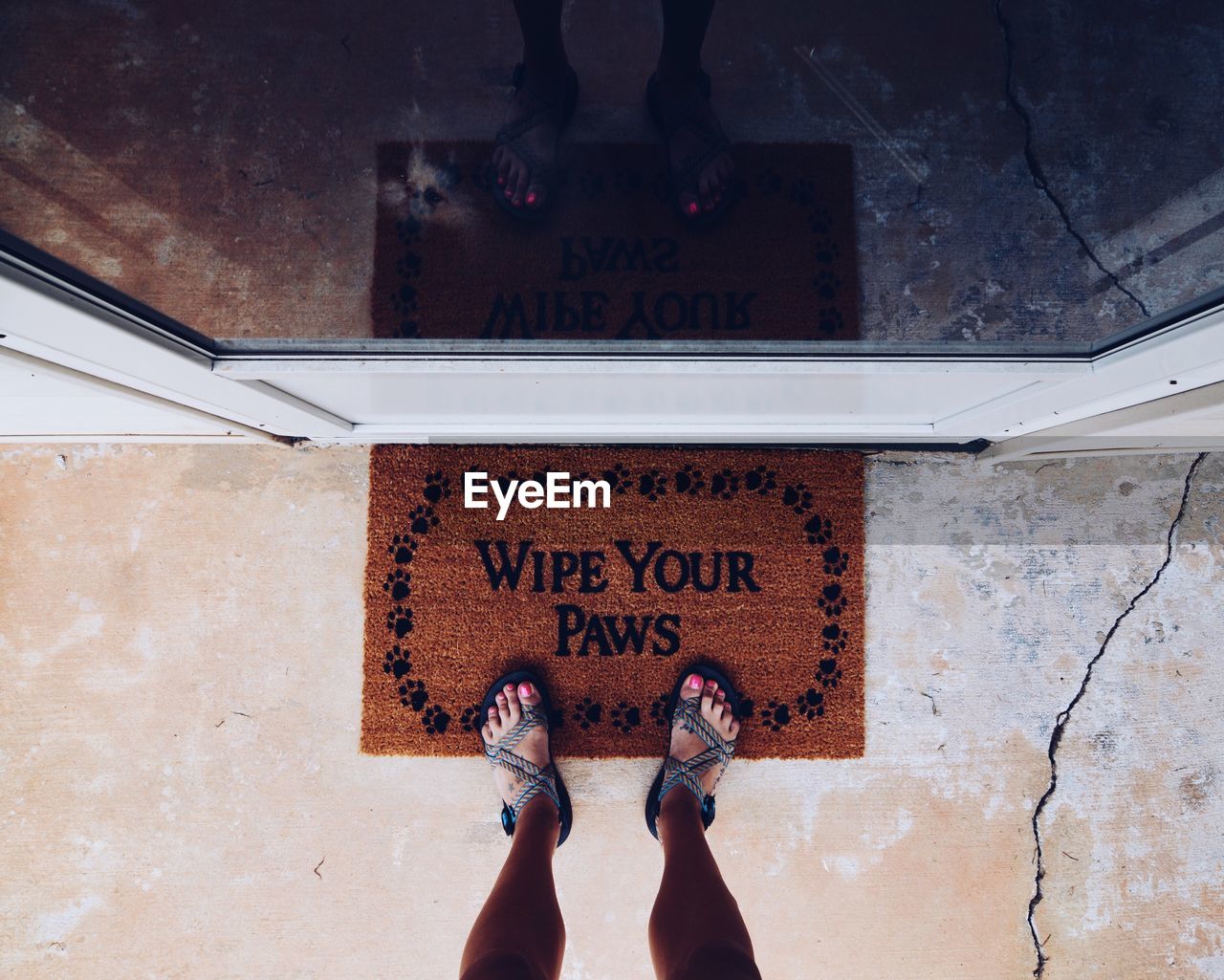 Low section of woman standing on doormat