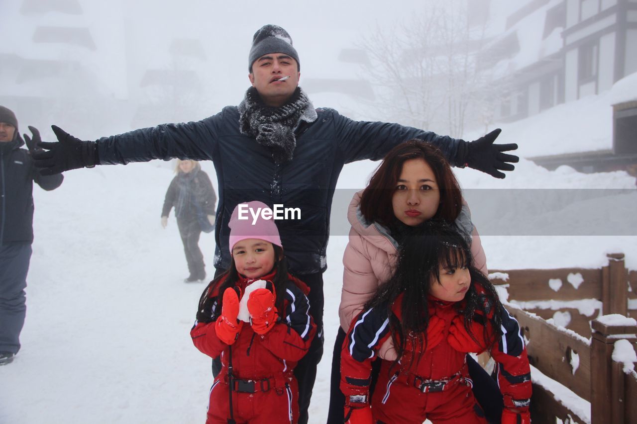 Portrait of young family enjoying in snow