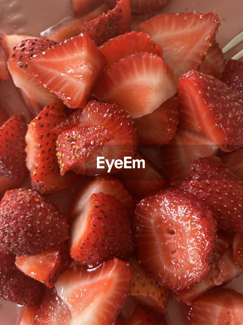 High angle view of chopped strawberries in plate