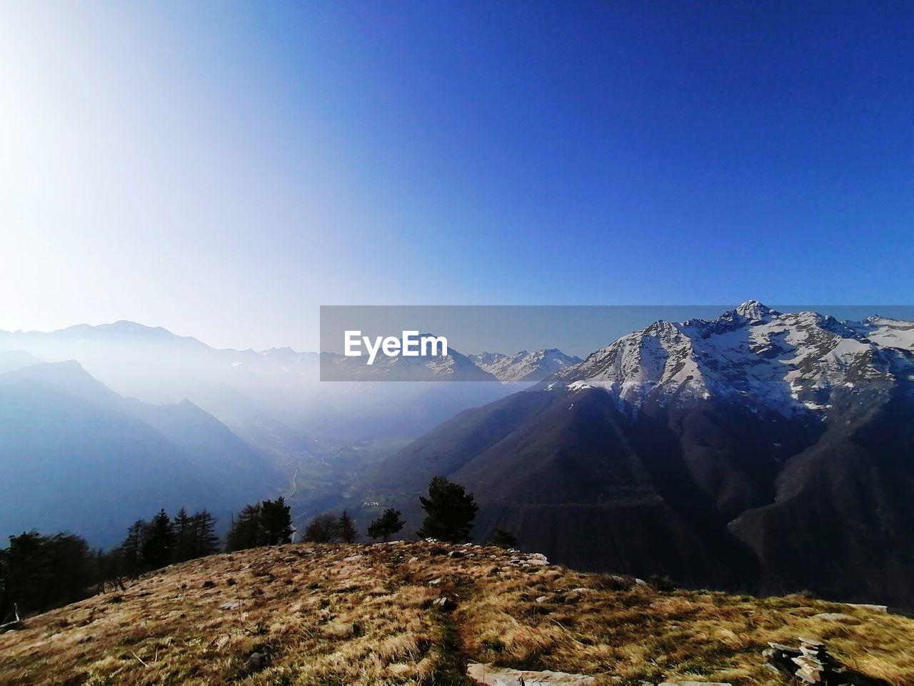 Scenic view of snowcapped mountains against clear blue sky