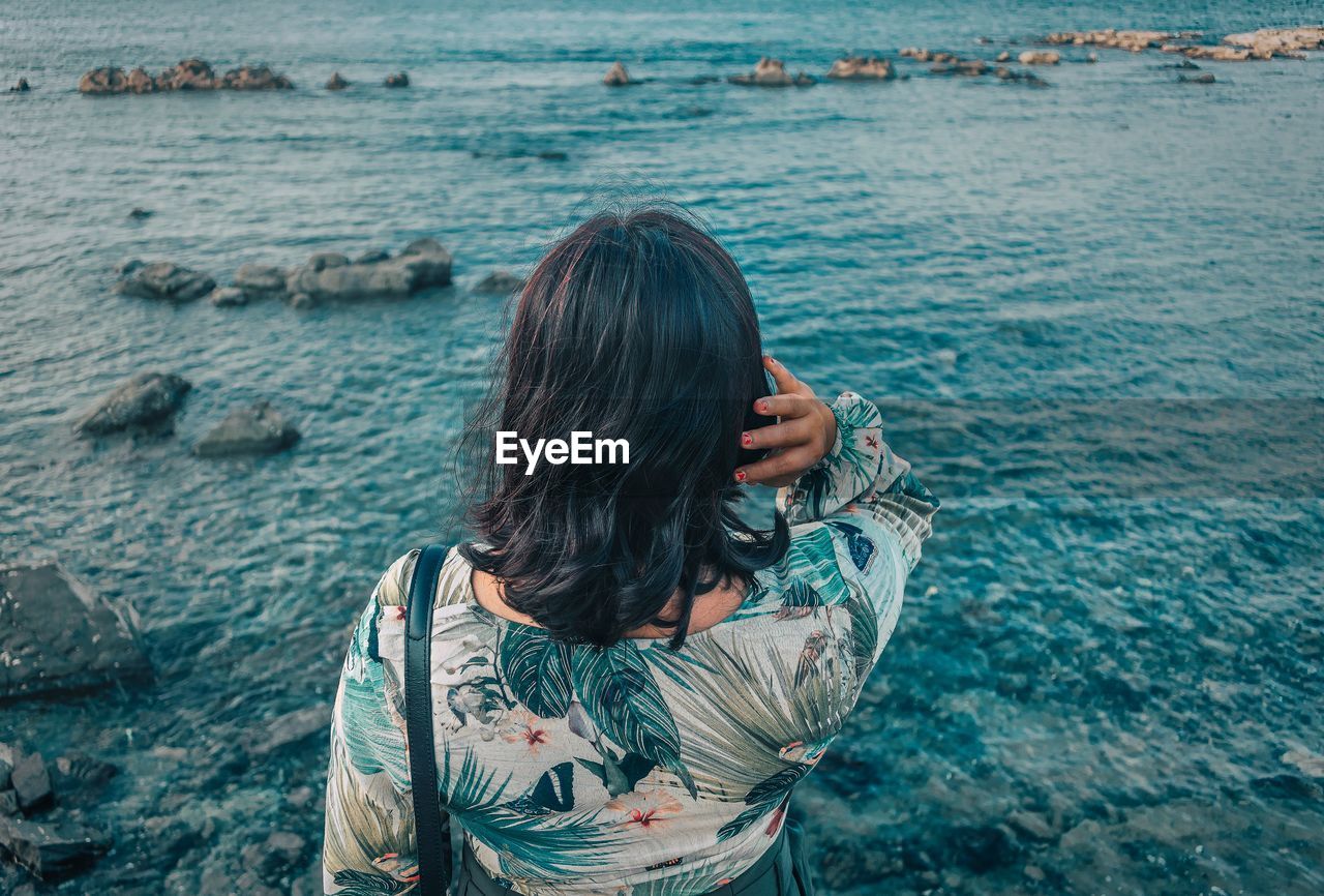 Rear view of woman standing in sea