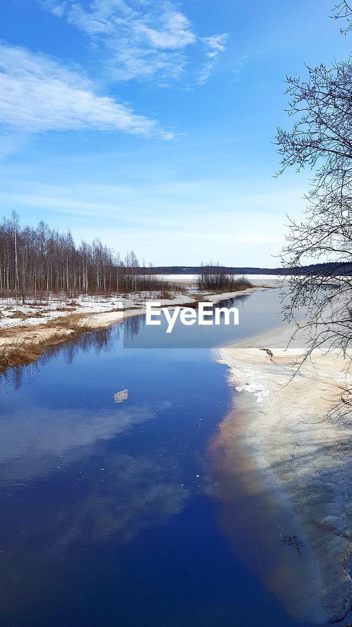 SCENIC VIEW OF LAKE AGAINST BLUE SKY DURING WINTER