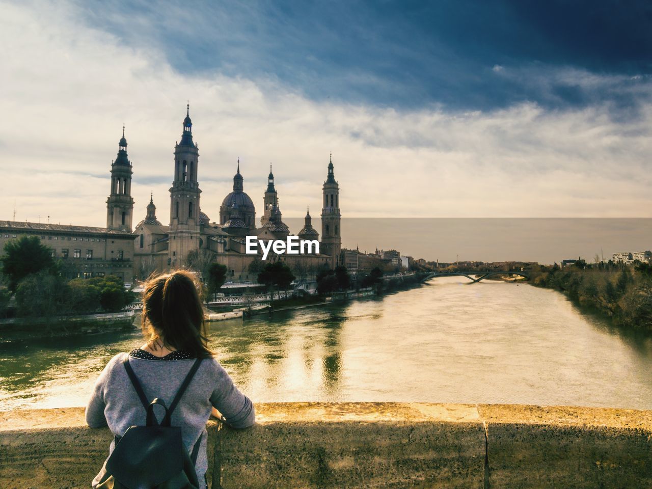 REAR VIEW OF WOMAN STANDING ON RIVERBANK