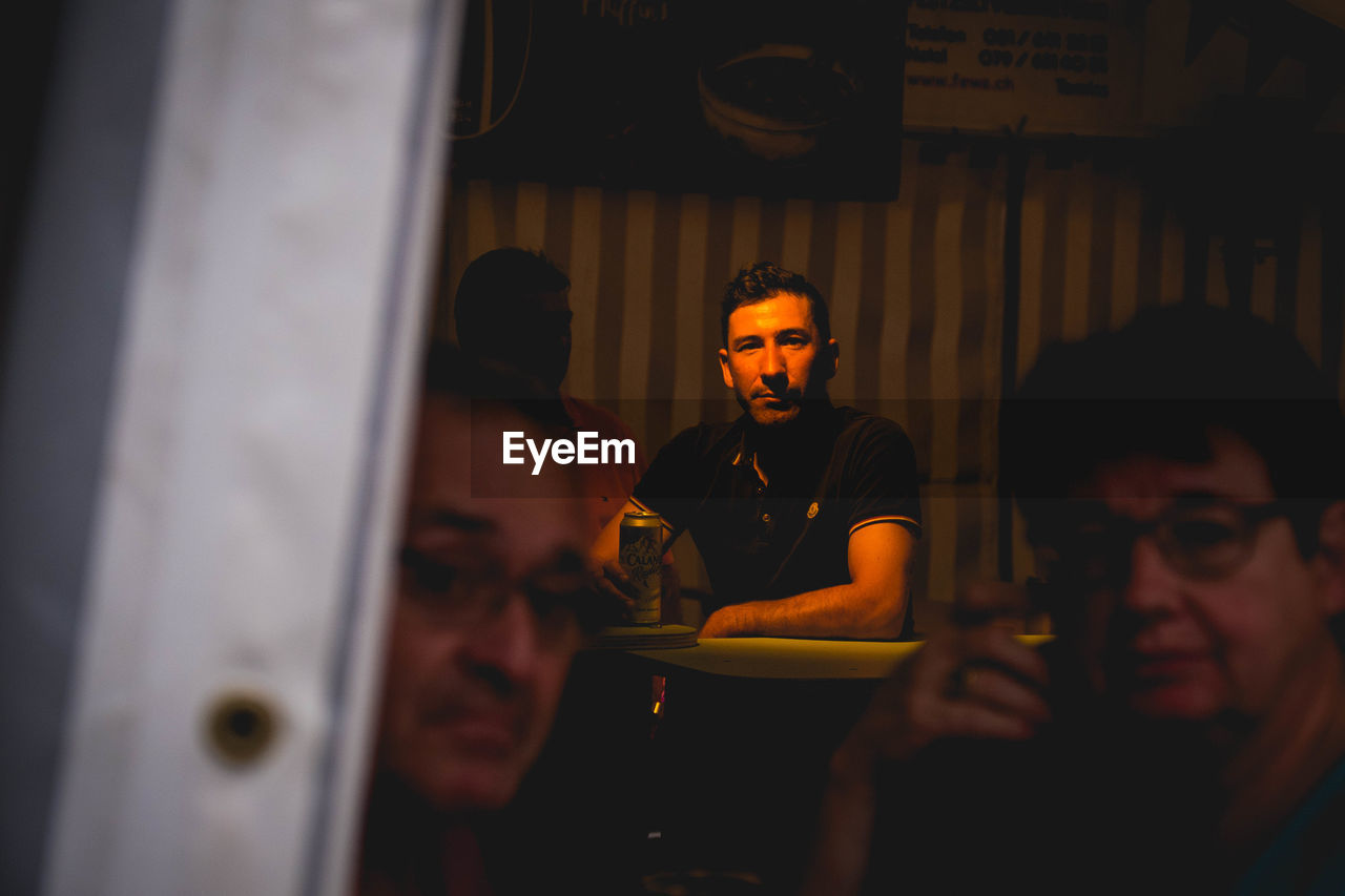 YOUNG MAN SITTING IN RESTAURANT