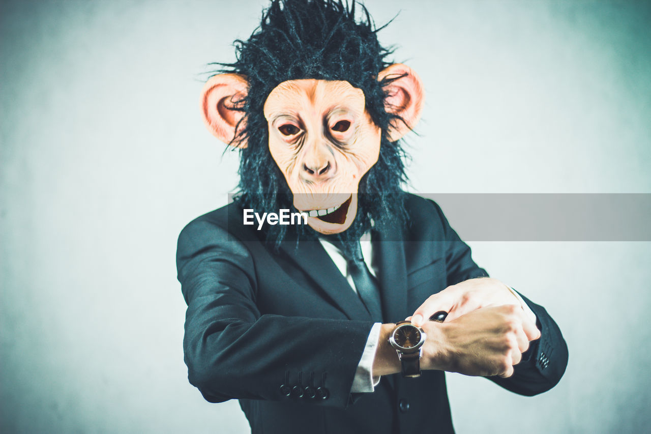 Man wearing monkey mask against white background