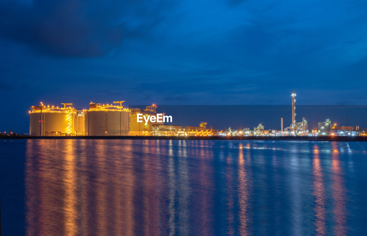 ILLUMINATED FACTORY BY SEA AT NIGHT