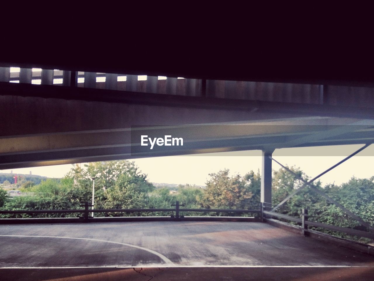 EMPTY ROAD BY TREES AGAINST SKY SEEN FROM WINDOW