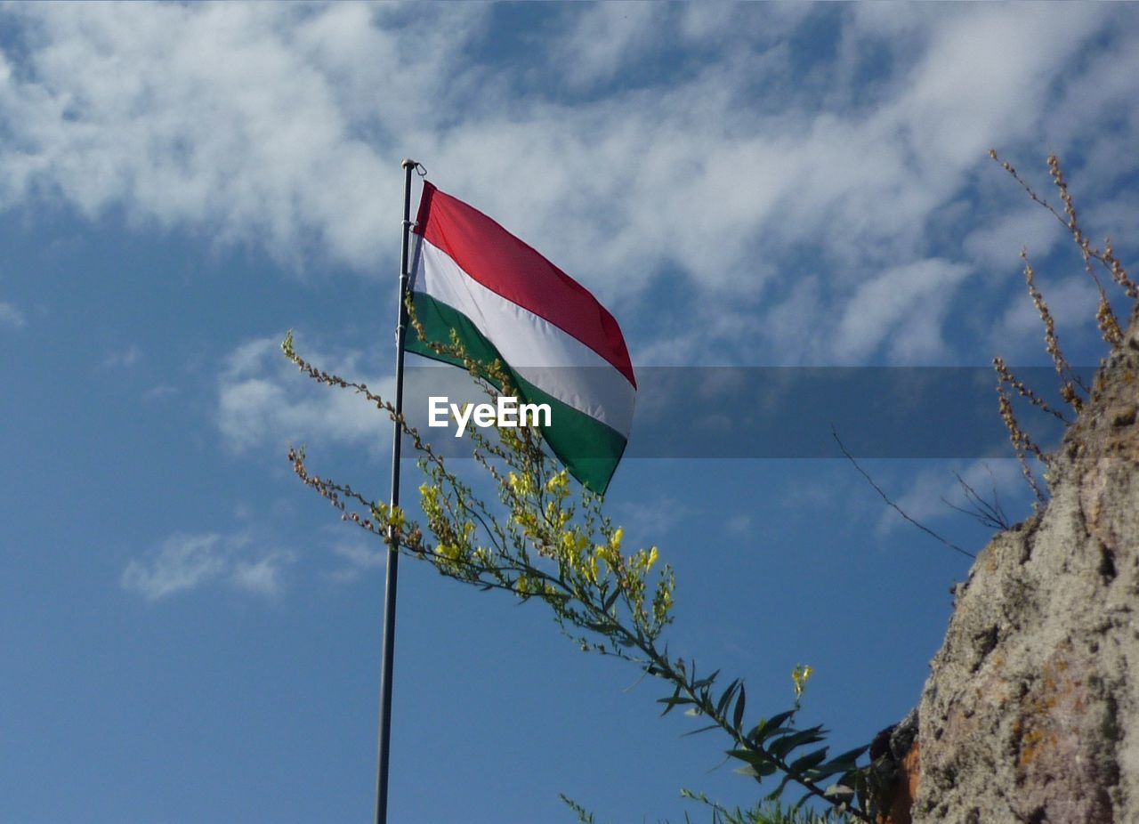 Low angle view of american flag against cloudy sky