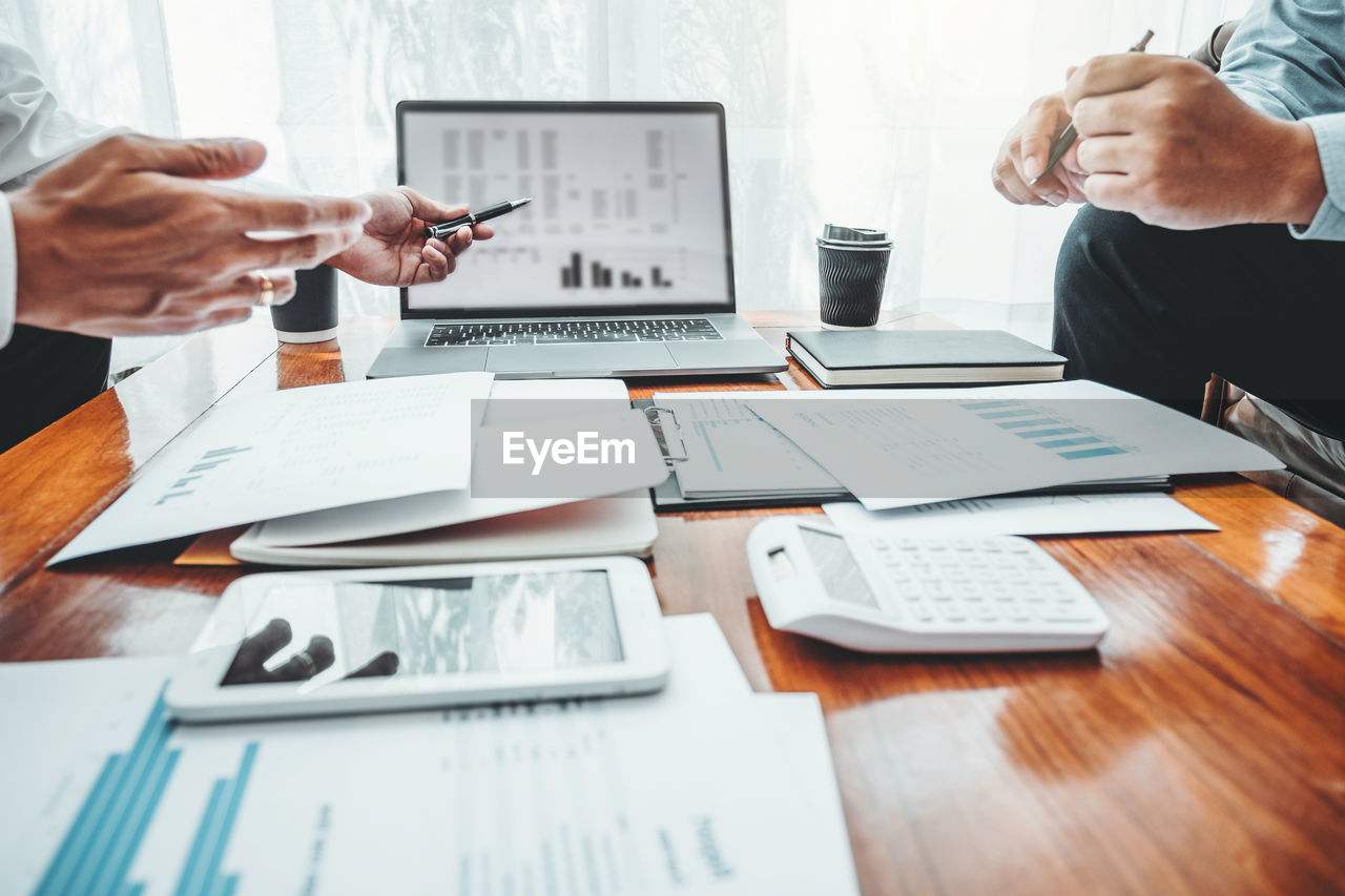 Cropped image of business colleagues working at desk in office