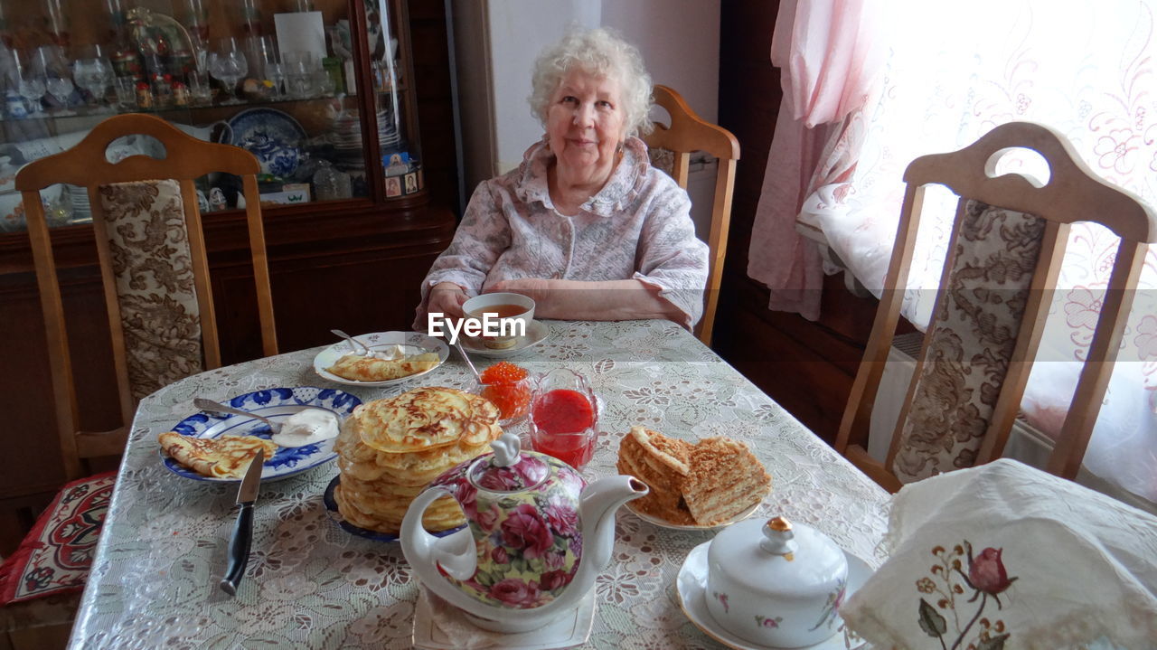 WOMAN SITTING ON TABLE AT HOME IN CAFE