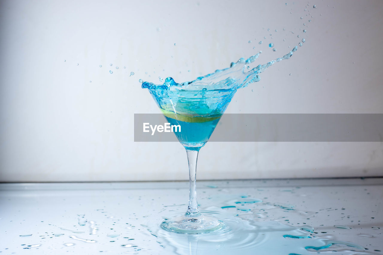 Close-up of glass of water on table against white background