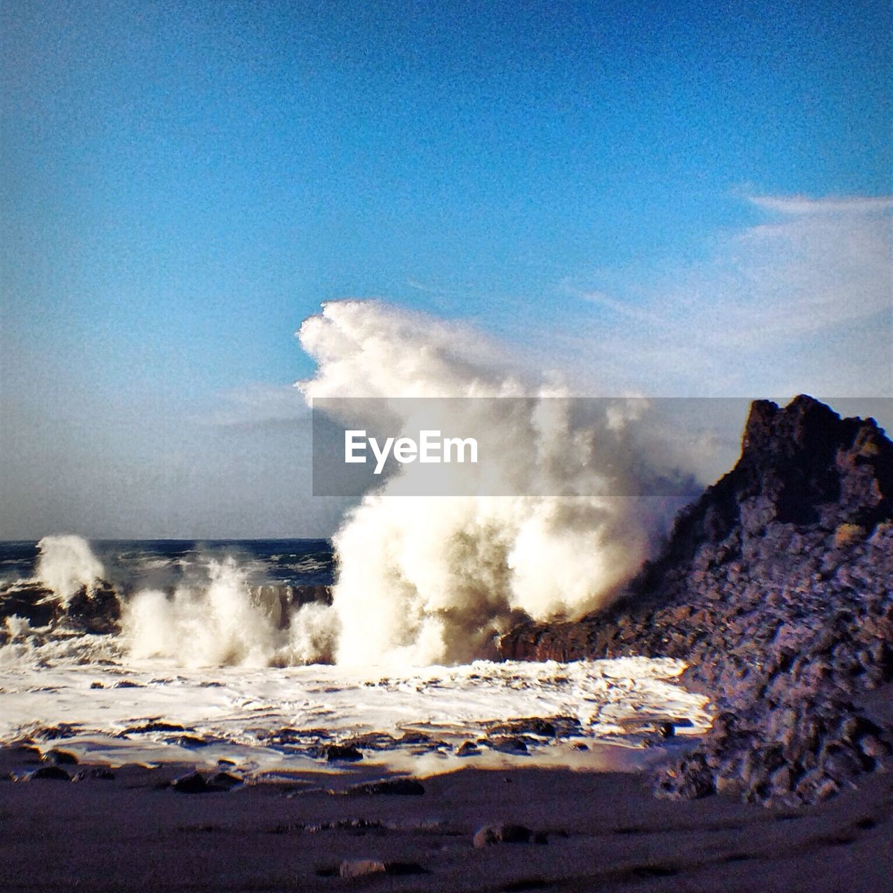 Wave crashing on rocks on beach