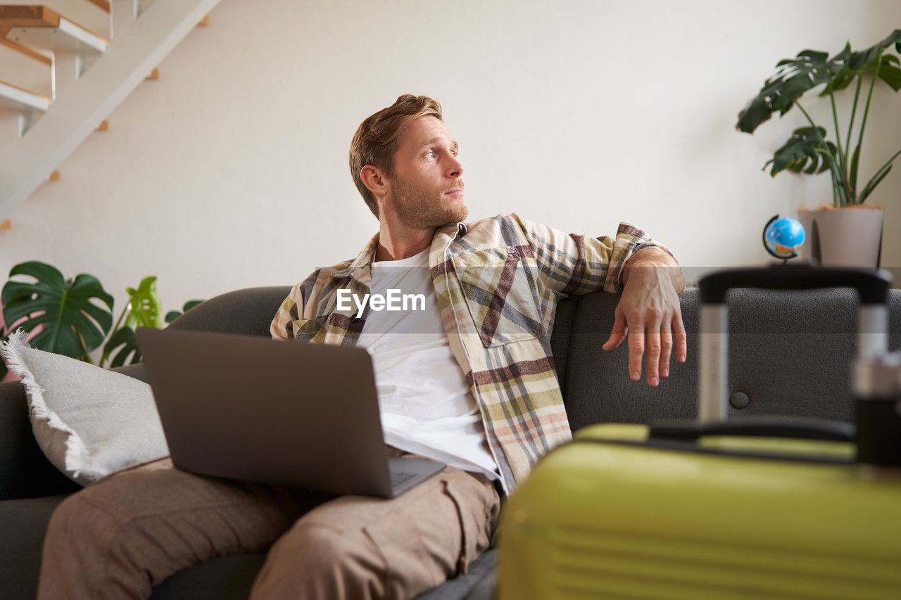 young man using laptop while sitting at home