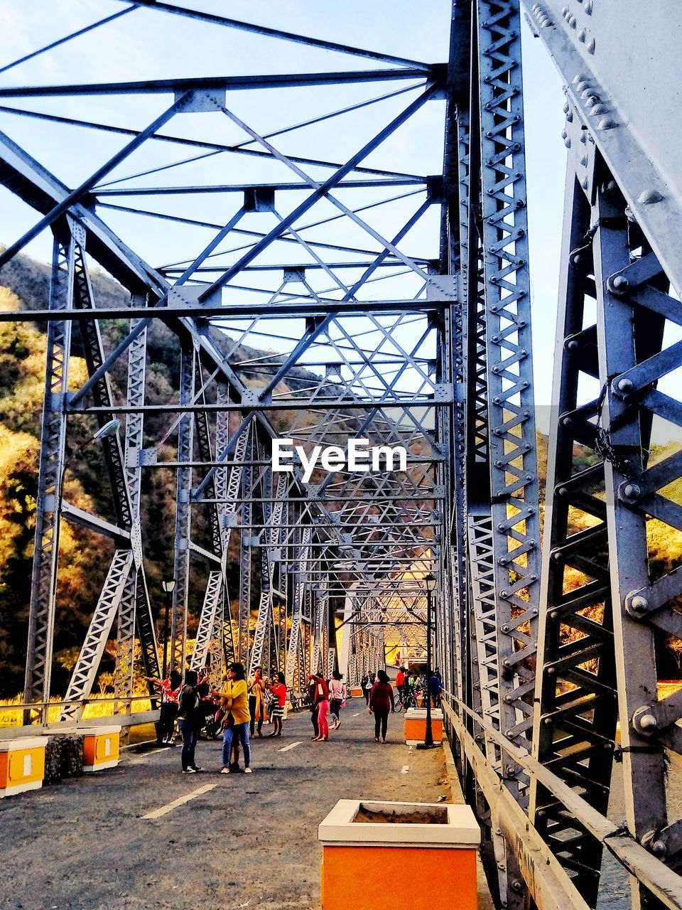 People walking on bridge against sky