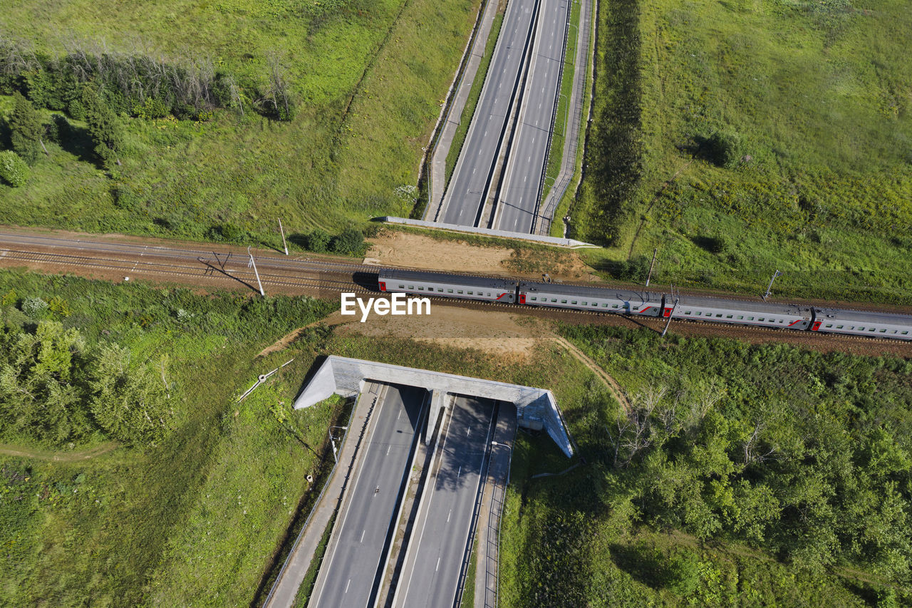 Aerial view of passenger train passing across railroad overpass