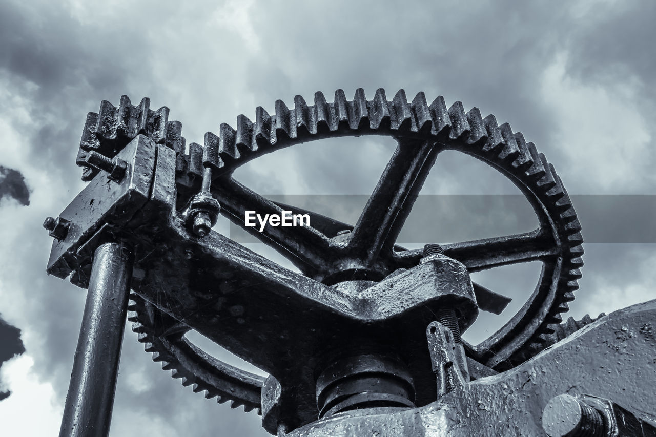 LOW ANGLE VIEW OF OLD MACHINERY AGAINST SKY