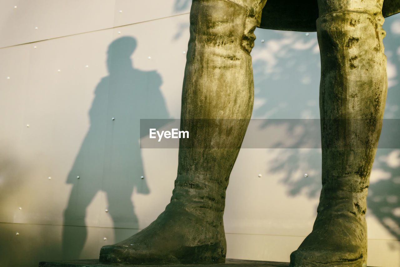 LOW SECTION OF MAN STANDING BY TREE